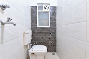 Un baño pequeño y moderno con inodoro, ducha y ventana.