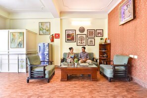 Una habitación con un sofá, una mesa de centro y una estantería.