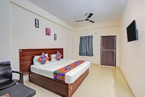 A bedroom with a bed, a ceiling fan, a door, and a chair.