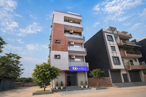 A multi-story hotel with a modern design, featuring balconies, air conditioning units, and a prominent hotel sign. - Fabhotel Shelter Inn (New Delhi)
