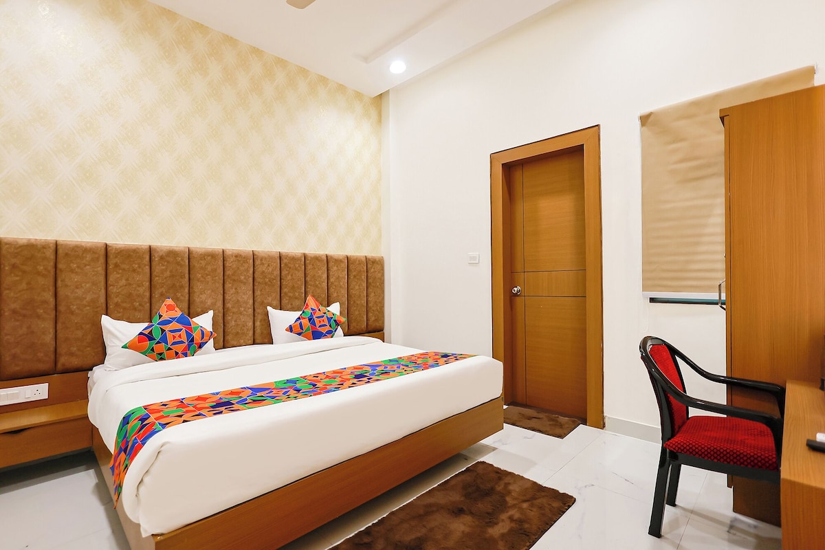 A bedroom with a bed, a desk, a chair, and a wardrobe.