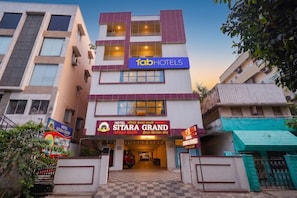 En høj bygning med et tydeligt skilt for hotel 'SITARA GRAND'.