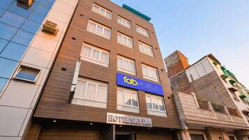 A multi-story hotel with a modern facade, a prominent 'fab hotels' sign, and a 'HOTEL SKY INN' sign.