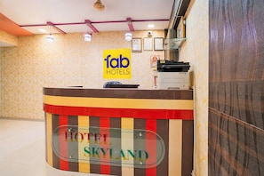 Una mesa de recepción de hotel con un letrero que dice 'fab hotels' y 'HOTEL SKYLAND'.