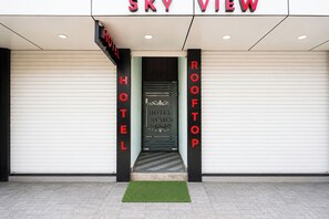 The entrance to the SKY VIEW HOTEL with a visible door and a green mat at the base.
