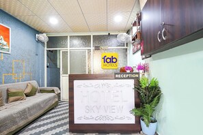 Un mostrador de recepción con un cartel que dice 'HOTEL SKY VIEW' y el logotipo de 'fab hotels' encima.