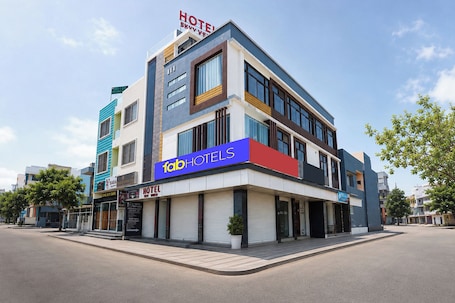 A multi-story hotel with a prominent 'fabHOTELS' sign, a rooftop terrace, and a modern architectural design.. Fabhotel Skyview