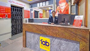 A hotel reception desk with a computer, a sign for room availability, and a welcome sign.