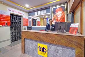 A hotel reception desk with a computer, a sign for room availability, and a welcome sign. - FabHotel Sri Sai Regency - Nr. RTC X Roads Metro Station (Hyderabad)
