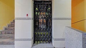 An elevator entrance with a metal gate, a stairway to the left, and a '2nd Floor' sign above.
