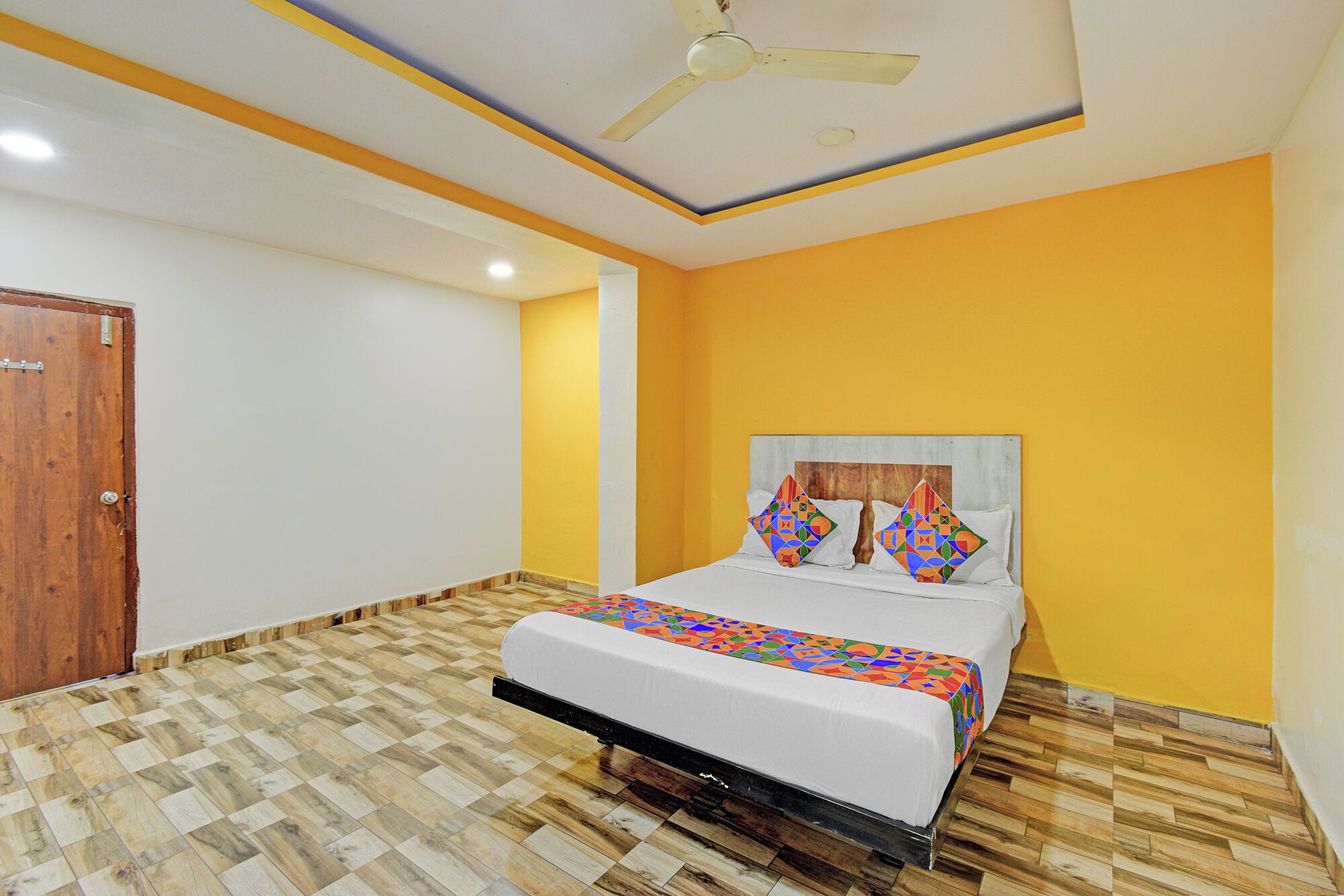 A bedroom with a bed, a ceiling fan, and a wooden door.