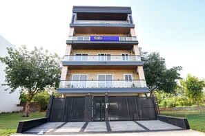 A multi-story building with a sign for 'fab hotels'. - Fabhotel The Mamta Grande (Gurugram)