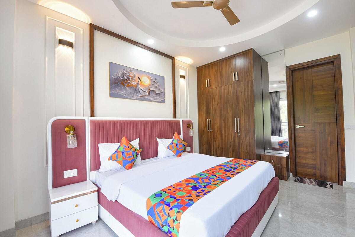A bedroom with a bed, nightstands, a wardrobe, and a ceiling fan.