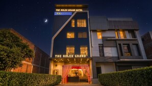 Un hotel con un letrero llamativo que dice 'THE ROLEX GRAND HOTEL' y 'fabHOTELS'.