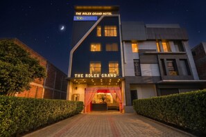 Un hotel con un letrero llamativo que dice 'THE ROLEX GRAND HOTEL' y 'fabHOTELS'.