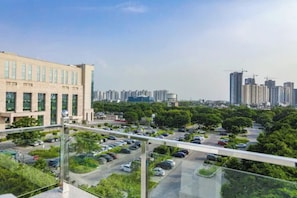 A high-rise building with a parking lot below. - Fabhotel Unique Stay (Noida)