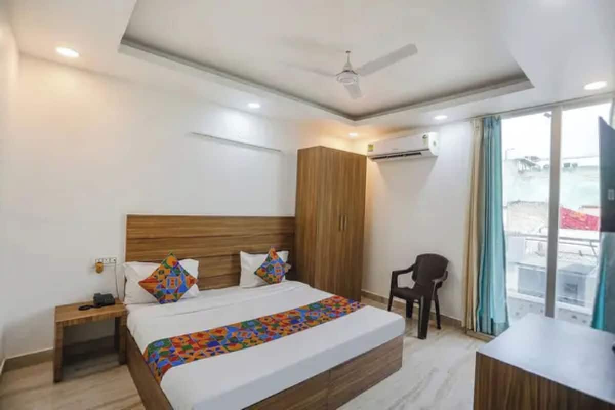 Ein Hotelzimmer mit Bett, Schreibtisch, Stuhl, Kleiderschrank und Deckenventilator.