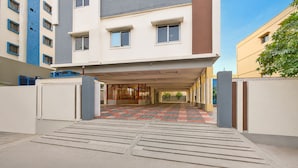 A building entrance with a tiled pathway leading to a covered area with glass doors. - FabHotel White Ridge Kamineni - Nr. Saroornagar Indoor Stadium- L.B Nagar (Hyderabad)