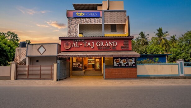 A multi-story building with a sign for 'fabHOTELS' and 'AL-TAJ GRAND' with a view of the sky and palm trees. - Fabhotel Whites Inn Vandalur (Chengalpattu)