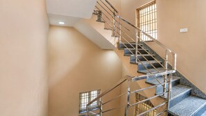 A staircase with metal railings and stone steps, leading to an upper floor. - Fabhotel Whites Inn Vandalur (Chengalpattu)