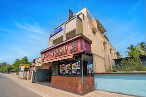 A building with a sign for 'Al-Taj Grand' and a Pepsi advertisement. - Fabhotel Whites Inn Vandalur (Chengalpattu)