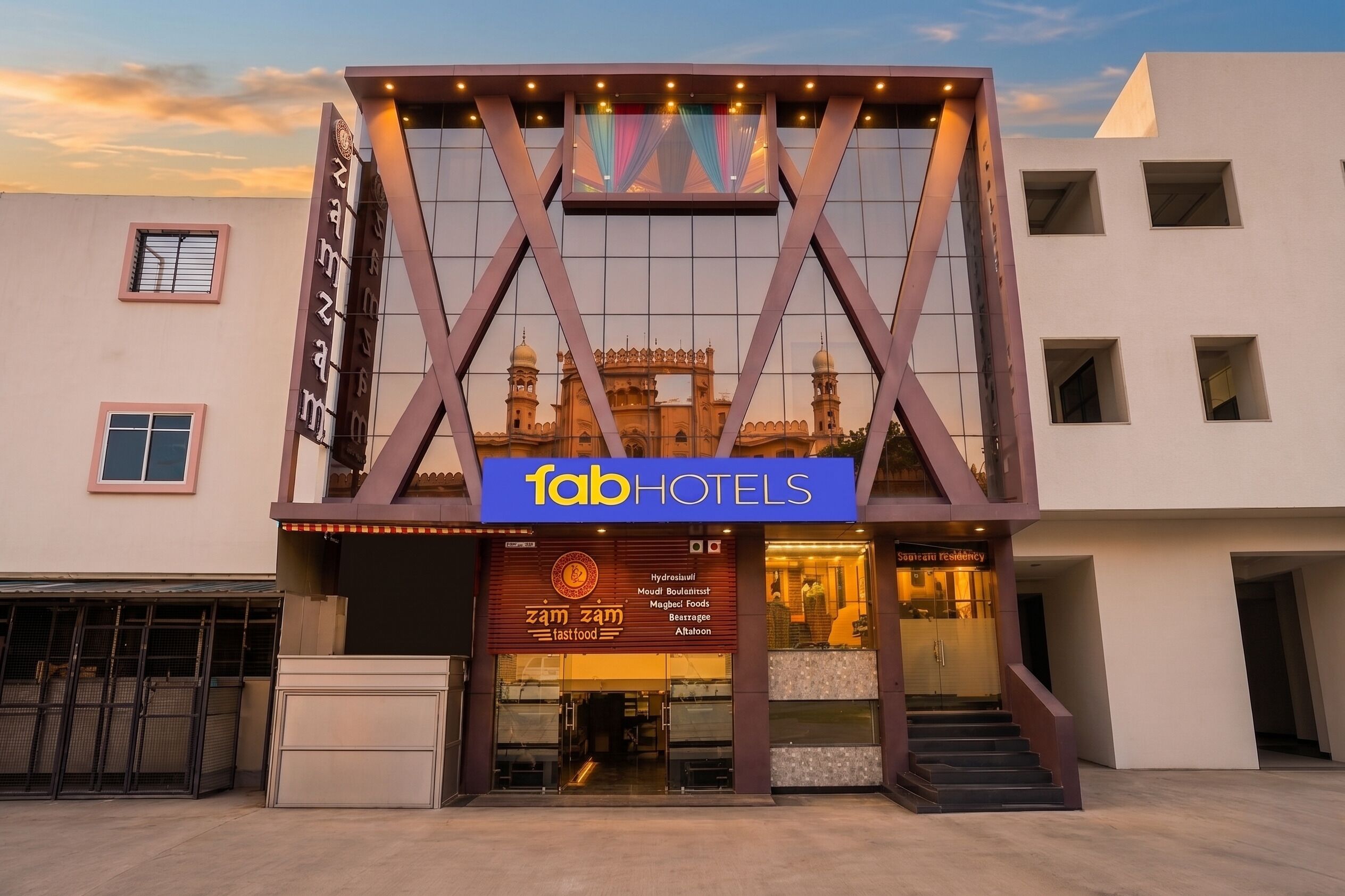 A hotel with a modern facade, a prominent sign for 'fabHOTELS,' and a visible entrance.