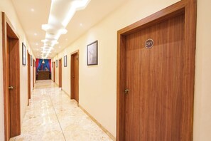 Un pasillo de hotel con puertas de madera, números 201, e imágenes enmarcadas en las paredes.