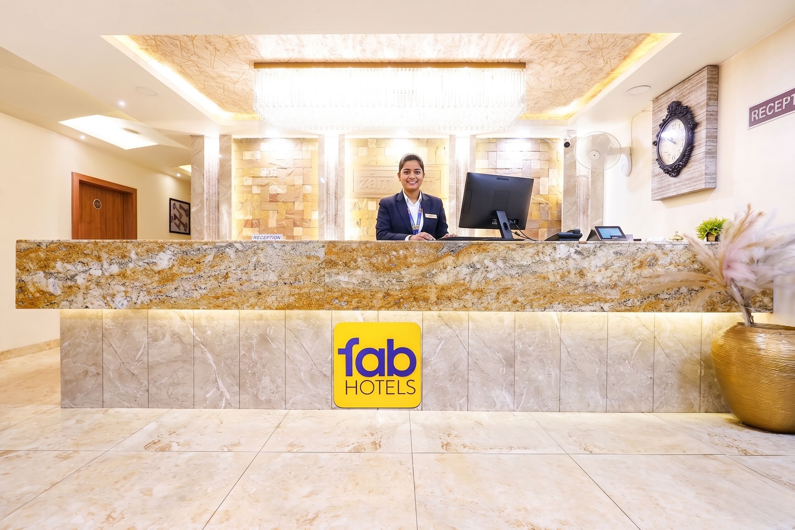 A hotel reception desk with a marble counter, a reception sign, a clock, and a reception sign on the wall.