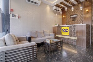 A modern hotel lobby with a sofa, a coffee table, and a reception desk. - Fabhotel Zillion Executive (Mumbai)