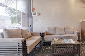 A modern interior with a sofa, a small table, and a patterned wall.