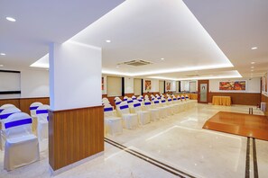 A conference room with rows of chairs, a wooden panel wall, and a marble floor. - Oriva Briklane (Bangalore)