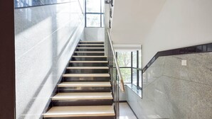A staircase with a metal railing, leading to an upper floor. - Fabhotel the prime Briklane -BTM Layout (Bangalore)