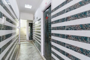 A hallway with a marble floor, white walls, and a door with a number '09' on it.