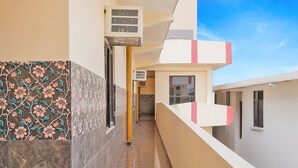 A narrow corridor with tiled walls, a yellow pole, and a window. - Via Balram - Metro Station Sector 34 Noida (Noida)