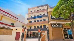 A multi-story building with a hotel entrance, a studio, and a cafe. - Via Balram - Metro Station Sector 34 Noida (Noida)
