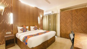 Ein Schlafzimmer mit Bett, Holzschrank, Deckenventilator und Klimaanlage.