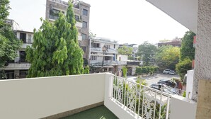 Ein Wohnbalkon mit Blick auf benachbarte Gebäude und parkende Autos.