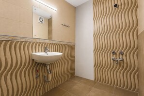 A bathroom with a sink, mirror, and shower. - Via Gem 92 (New Delhi)