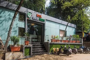 A building with a sign reading 'HOTEL GREEN HOUSE.' - Via Green Forest (Mumbai)