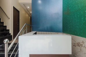 A staircase with a metal handrail and a white landing area. - Via Green Forest (Mumbai)