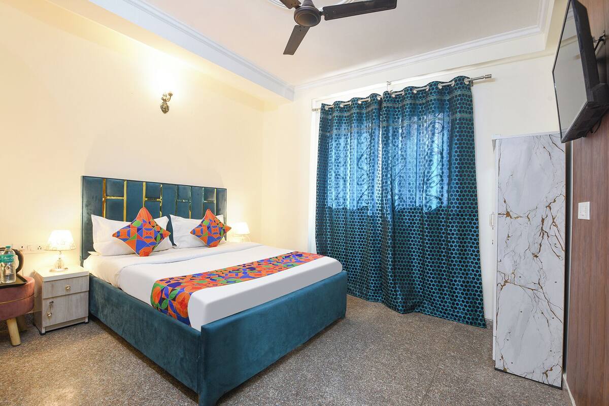 A bedroom with a bed, nightstand, lamp, and a ceiling fan.