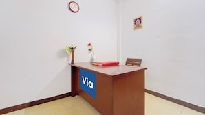 A reception desk with a clock and a framed picture on the wall. - Via Zane - Nr Coimbatore International Airport (Coimbatore)