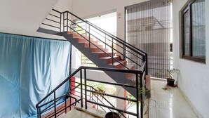 A staircase with metal railings, a blue curtain, and a potted plant. - Via Zane - Nr Coimbatore International Airport (Coimbatore)