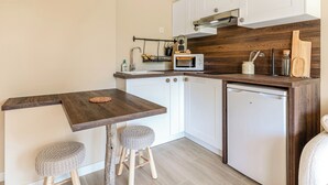 A compact kitchen with white cabinets, a wooden countertop, a microwave, and a small refrigerator. - Newly studio apartment in a quiet residence (Mandelieu-la-Napoule)
