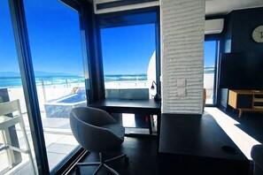 A modern room with a large window, a desk, a chair, and a television. - apartment with terrace in Saint-Cyprien (Saint-Cyprien)