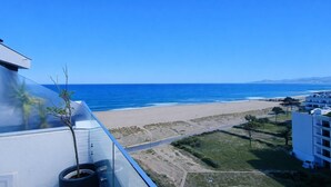 A coastal view with a clear sky, a beach, and a building with a balcony overlooking the ocean. - apartment with terrace in Saint-Cyprien (Saint-Cyprien)