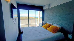 A bedroom with a bed, a view of the outdoors, and a wall-mounted air conditioner. - apartment with terrace in Saint-Cyprien (Saint-Cyprien)