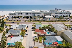 Ein Küstenhotel mit mehreren Gebäuden, einem Parkplatz und Blick auf den Strand.