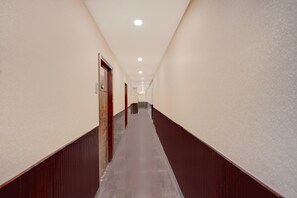 A long, narrow hallway with a wooden floor and walls, leading to a door at the end. - Classic Imperial Nest (Danapur)
