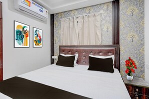 A bedroom with a bed, air conditioning unit, curtains, and wall art. - Classic Imperial Nest (Danapur)
